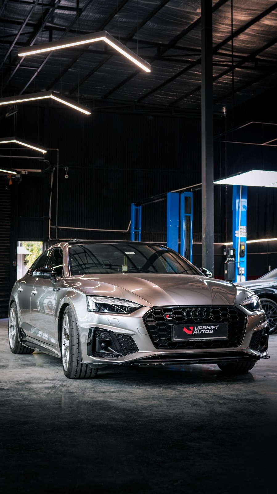 The silver Audi S5 Sportback, front three-quarter view in the workshop hall.
