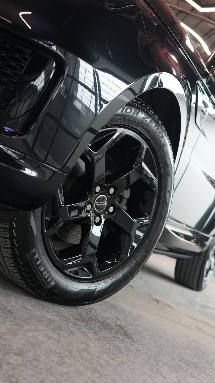 Close view of a gloss black alloy wheel and wheel arch on the black SUV.